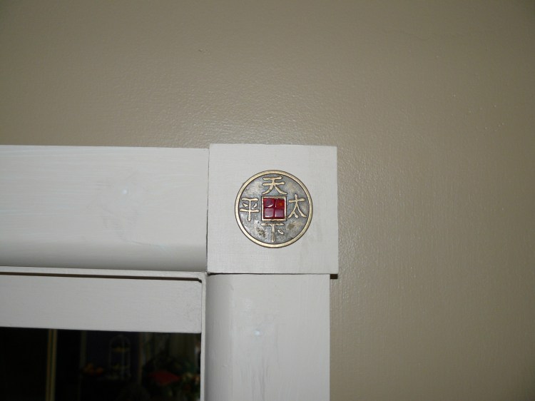 The corner of each window and door have Chinese coins with glass tiles mounted on a block.